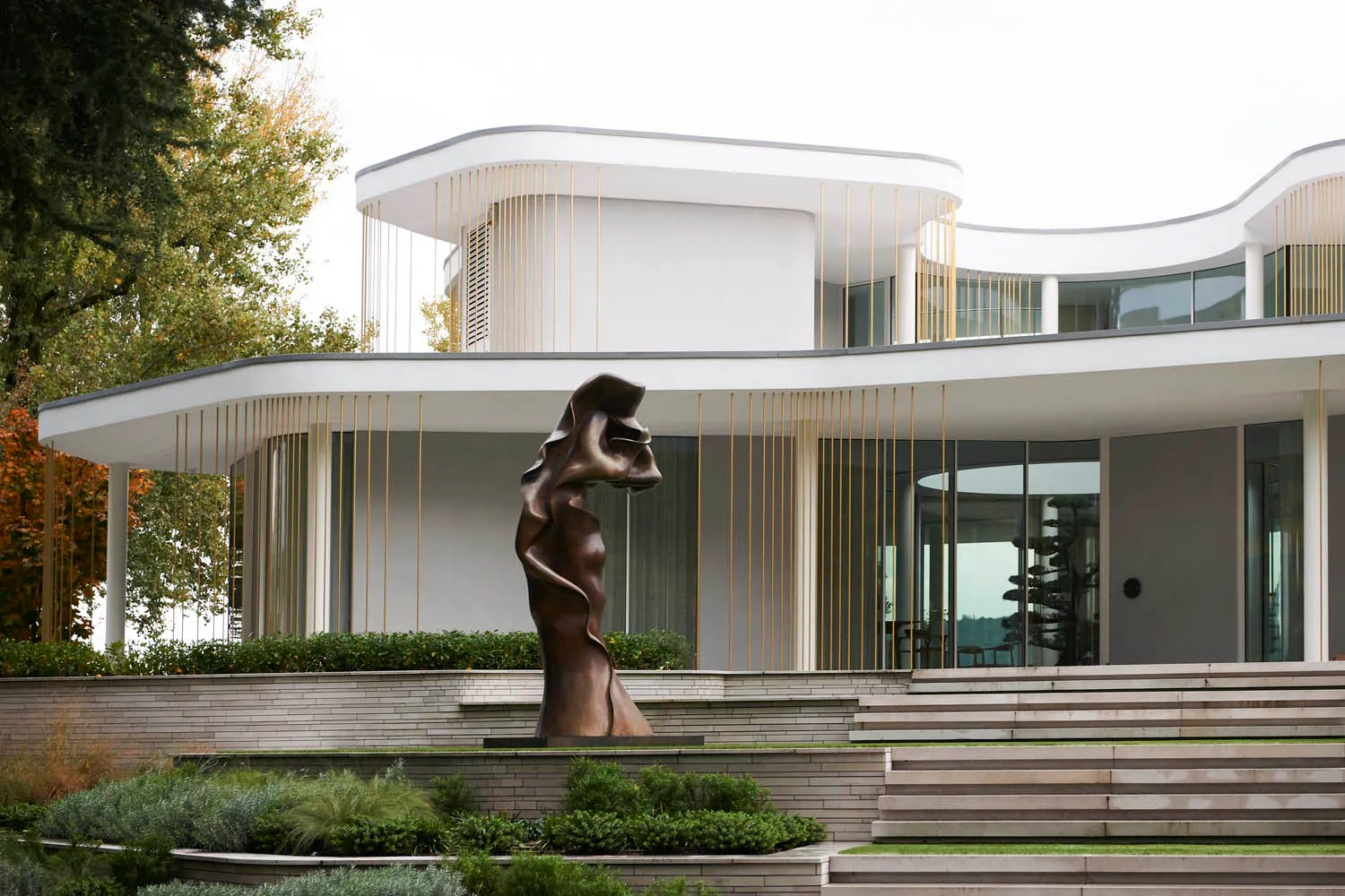A modern residential exterior featuring concrete and glass materials.