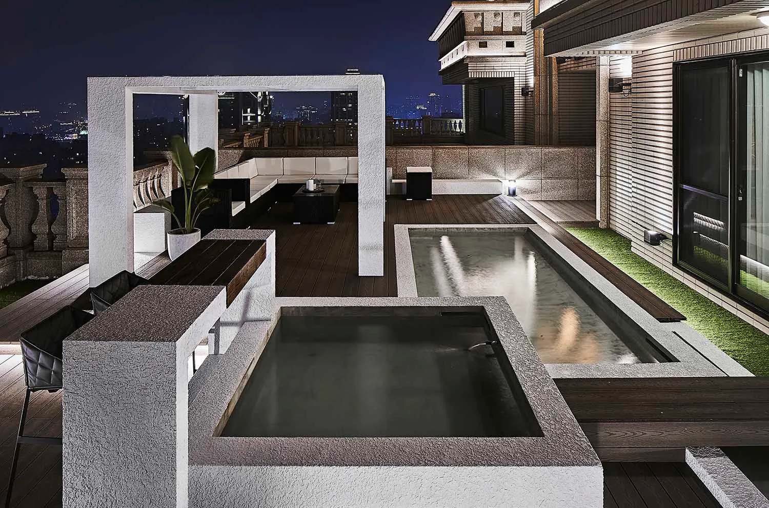 An outdoor residential patio featuring concrete and glass elements.