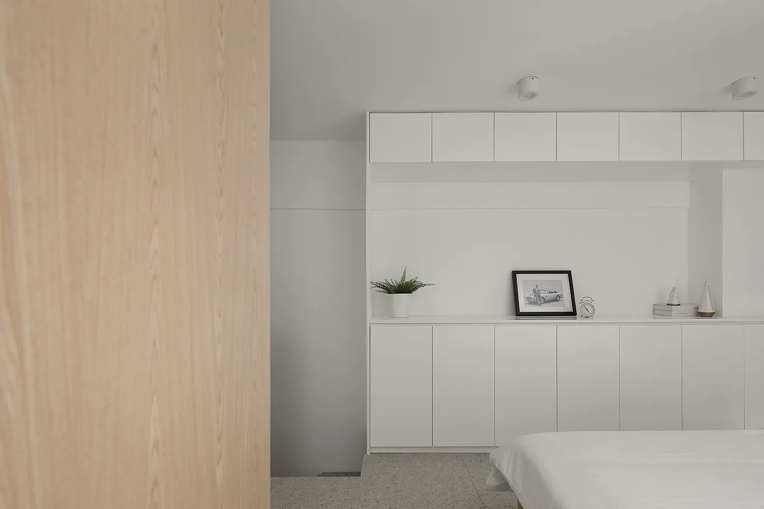 Minimalist residential interior featuring white color scheme, terrazzo flooring, and modern furniture.