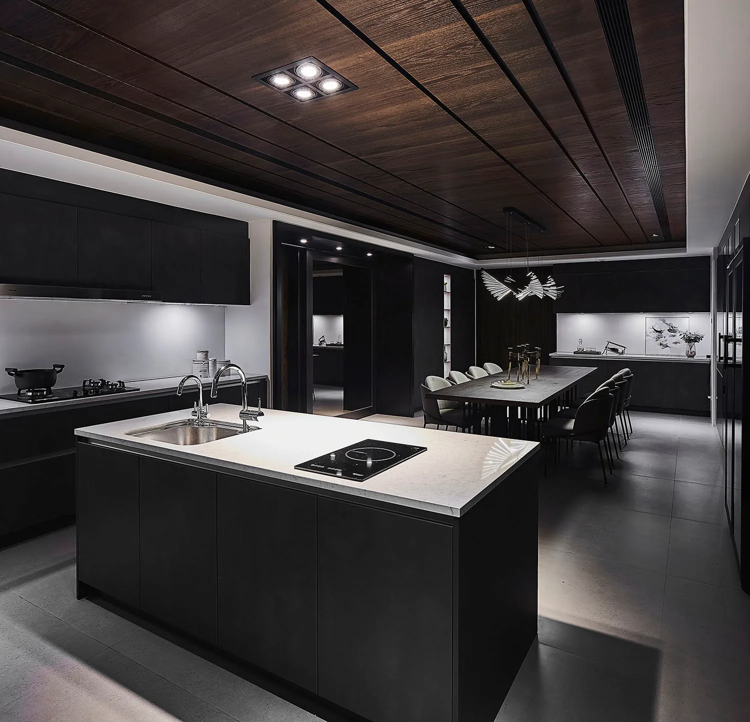 Modern black kitchen and dining room with concrete countertops and dark wood accents