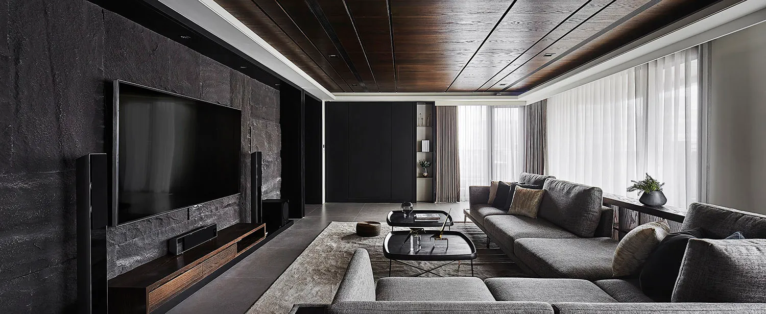 Modern living room featuring black walls, glass elements, and concrete flooring.