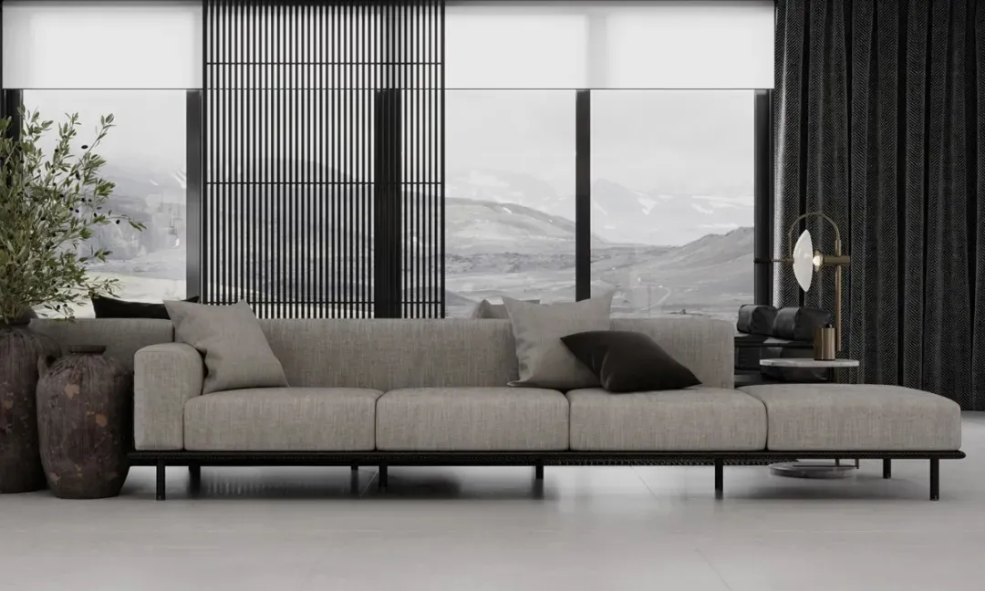 Modern living room featuring a large grey couch with black and grey throw pillows, a black floor lamp, large windows with mou