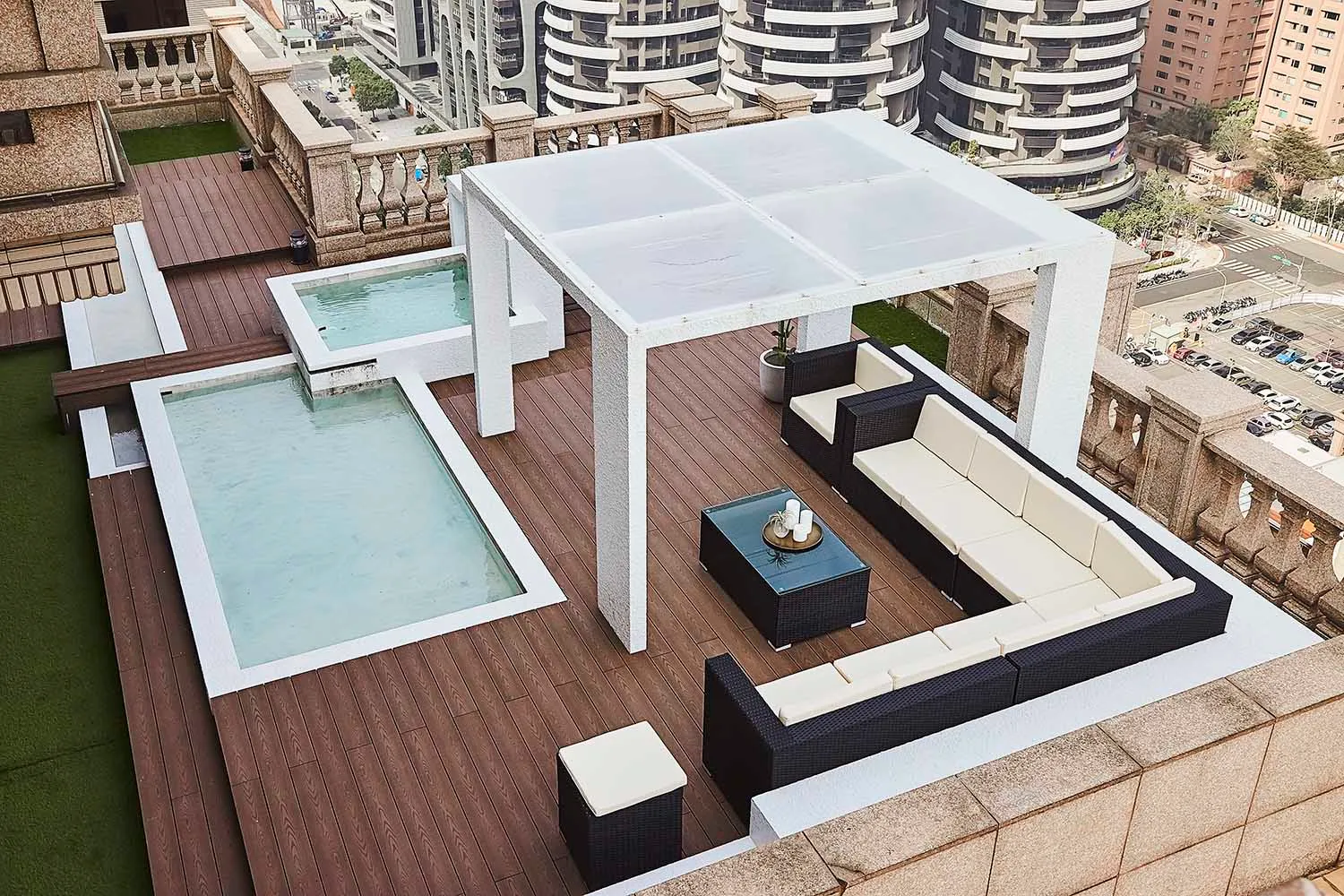 Modern rooftop terrace with concrete pools, lounge seating, and a pergola