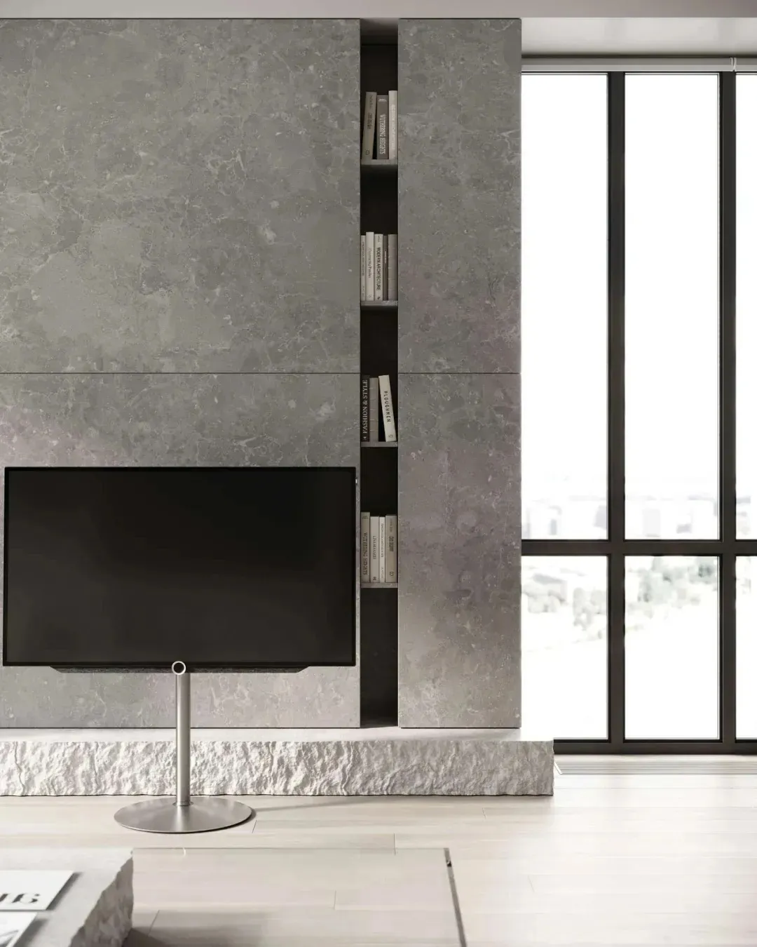 A modern living room with a concrete floor and wall, featuring a sleek flat-screen TV on a stand.