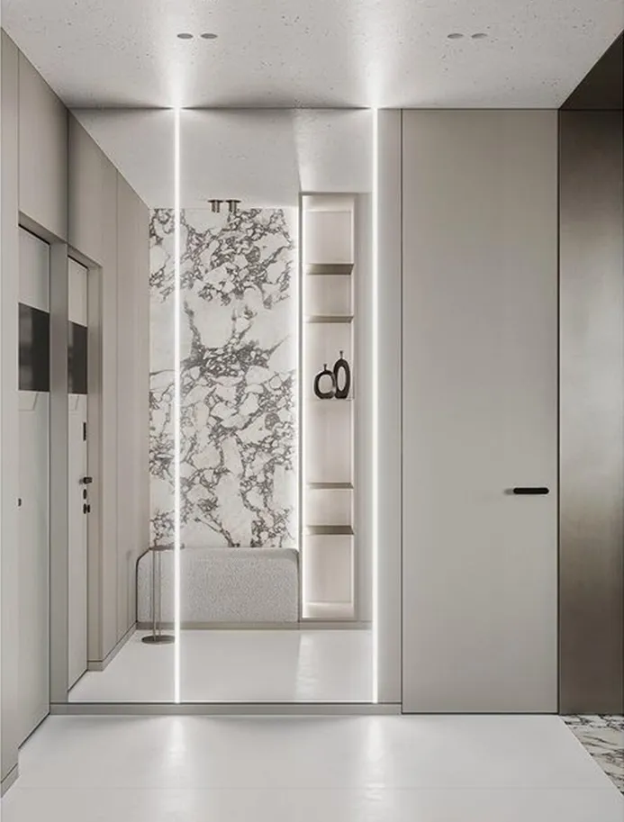 Modern bathroom with a marble panel wall, white walls, and a minimalist design.