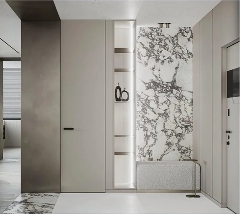 Modern entryway featuring white marble tiles and a shelf with black vases.