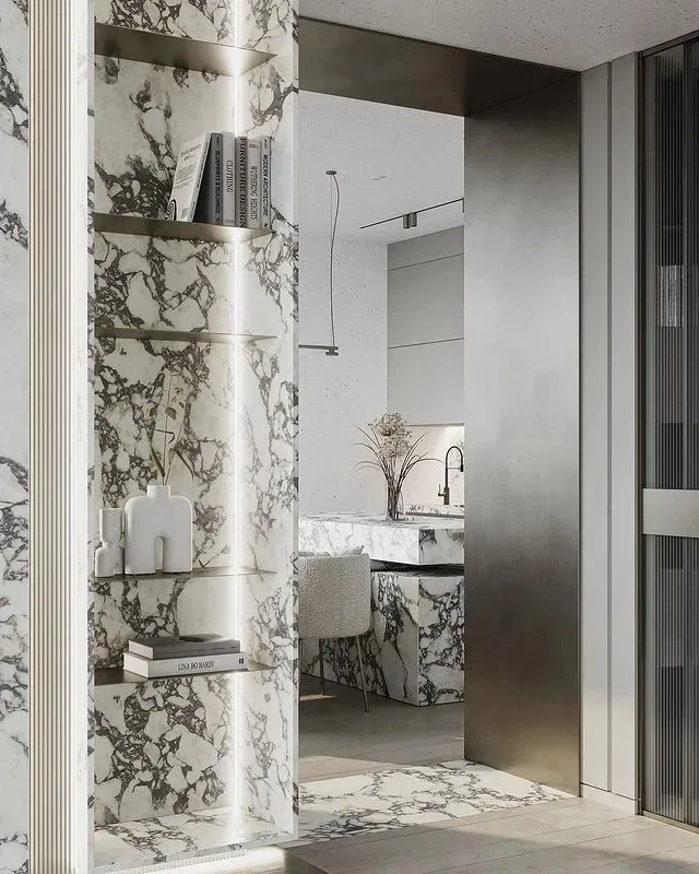 Modern kitchen featuring white and gray marble countertops and backsplash with metallic accents.