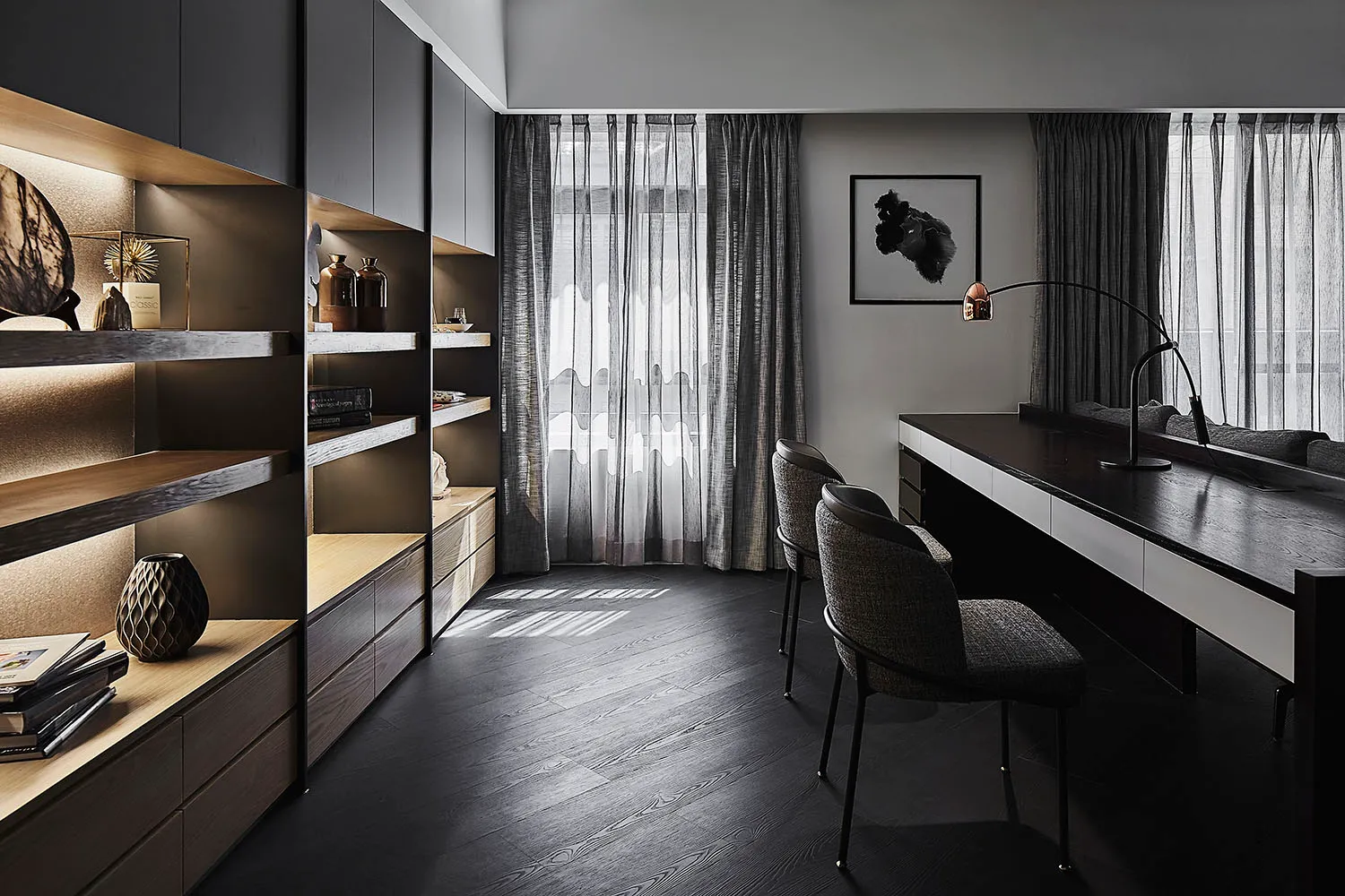 A modern office space featuring black metal and glass furniture, minimalist decor, and large windows with sheer curtains.