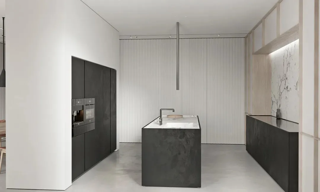 A modern kitchen with a central island featuring a concrete countertop and floor-to-ceiling cabinets.