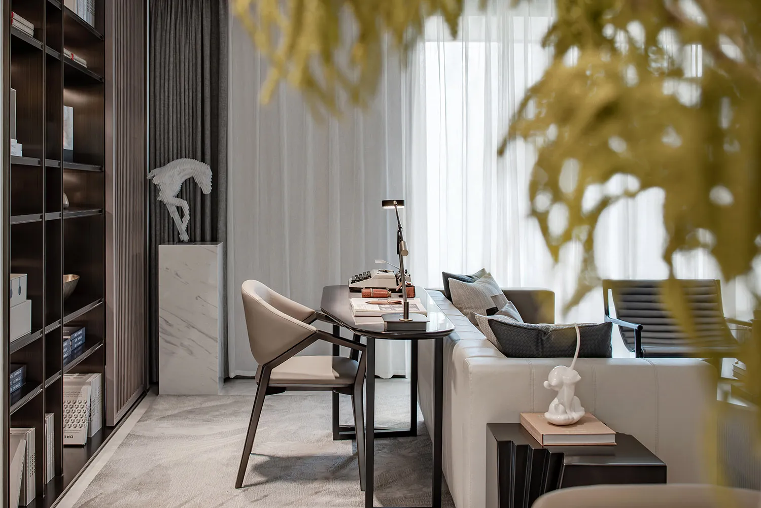 Modern home office featuring a sleek, minimalist desk with a marble top, a comfortable sofa, and stylish decor.