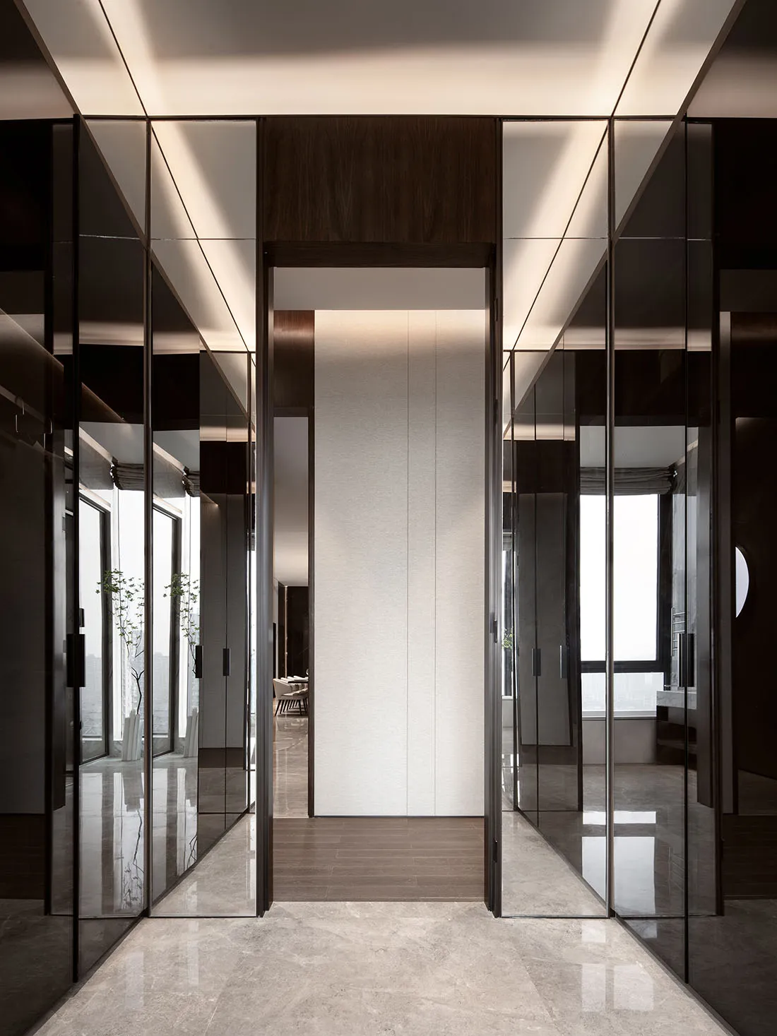 A minimalist corridor with glass walls and marble flooring.
