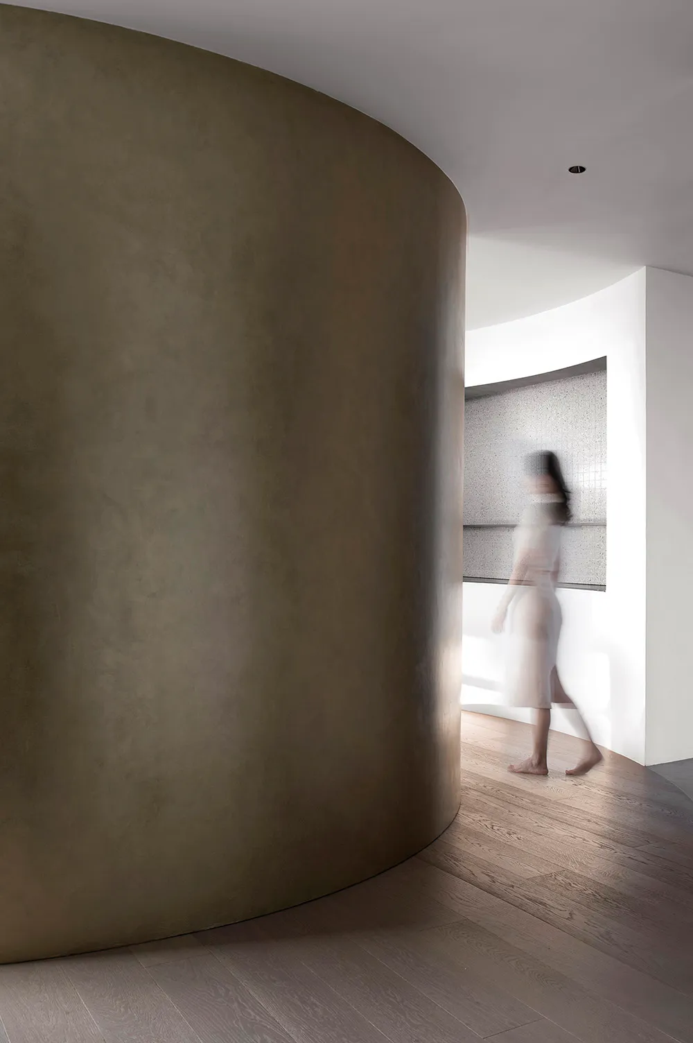 A minimalist interior with concrete walls and wooden flooring.
