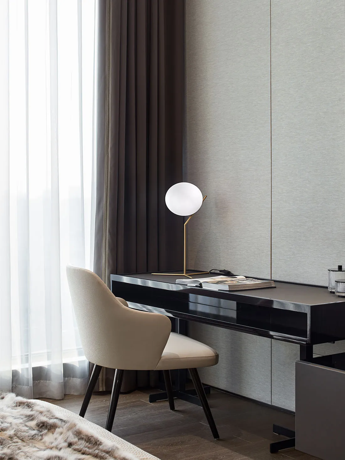 A minimalist office setup featuring a sleek desk with a modern lamp and a comfortable chair.