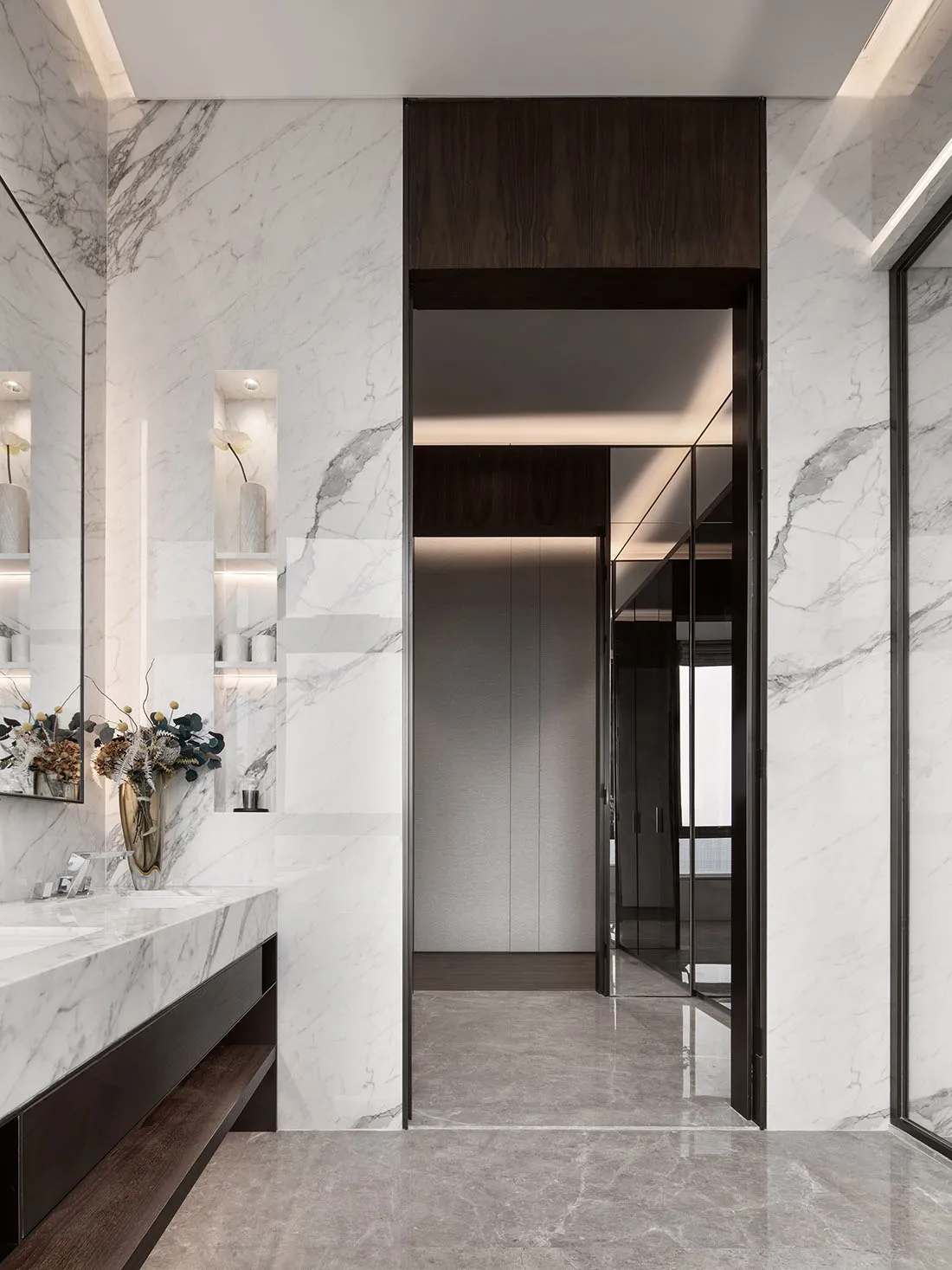 Modern bathroom featuring marble walls and flooring, minimalist design, and sleek fixtures.