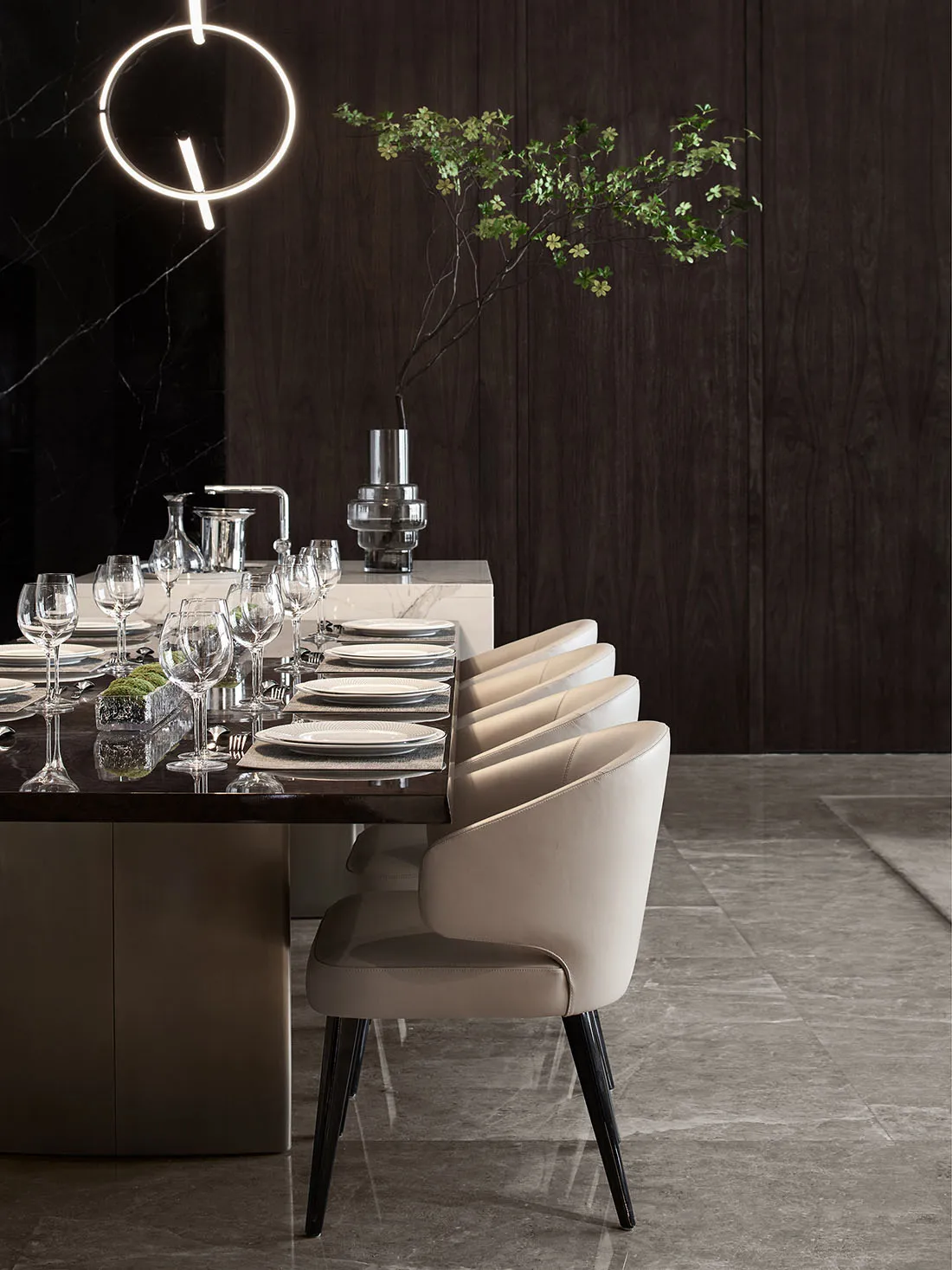 Modern dining room featuring a sleek dining table with white leather dining chairs, surrounded by a stylish marble counter an