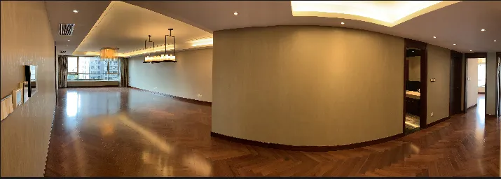 A spacious, modern living room featuring hardwood flooring.