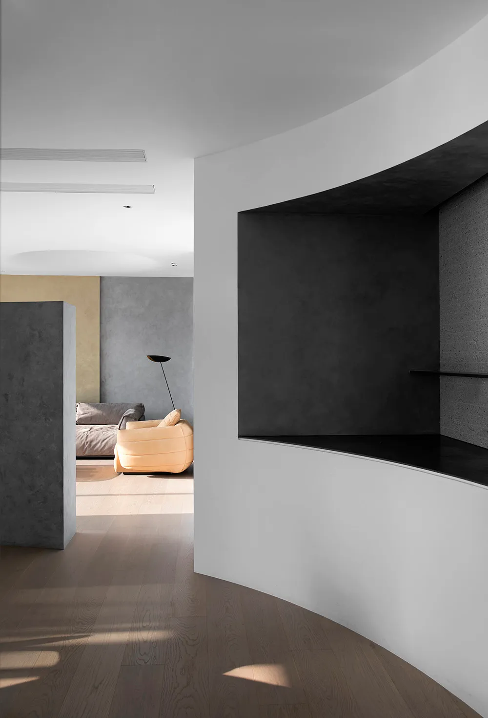 Modern living room featuring a wooden floor and concrete walls.