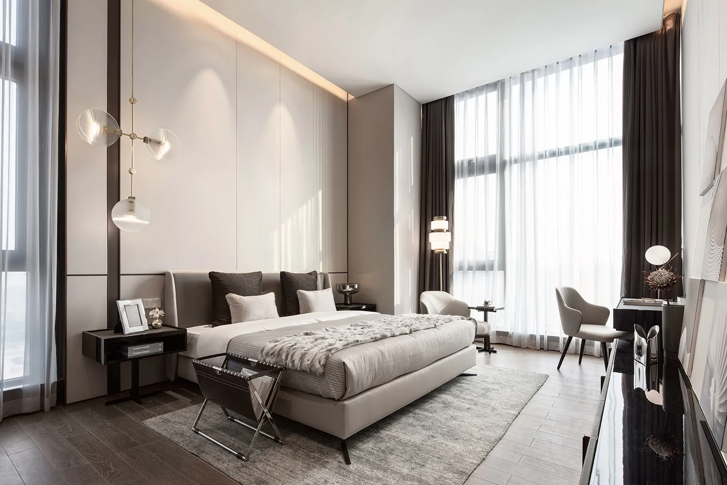 A modern bedroom featuring a bed with light wood furniture and a large window with sheer curtains.