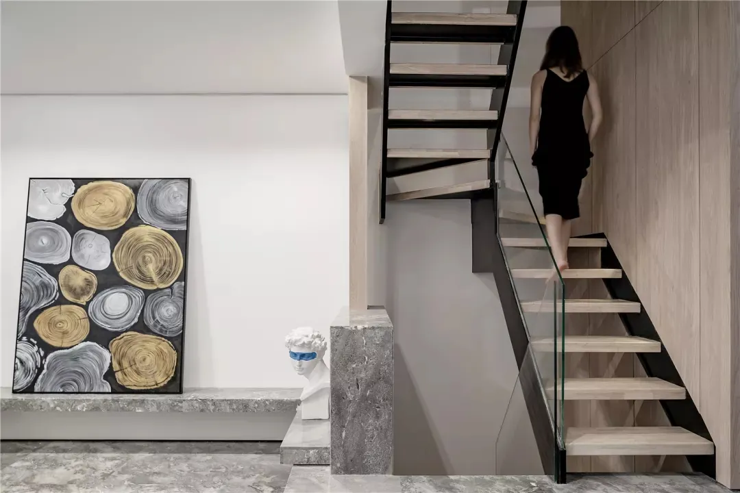 A modern interior design featuring glass, concrete, and wooden elements.