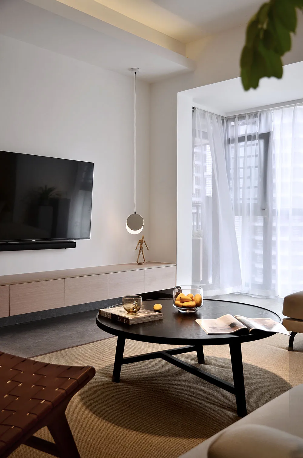 Modern minimalist living room with wood, glass, and fabric materials.