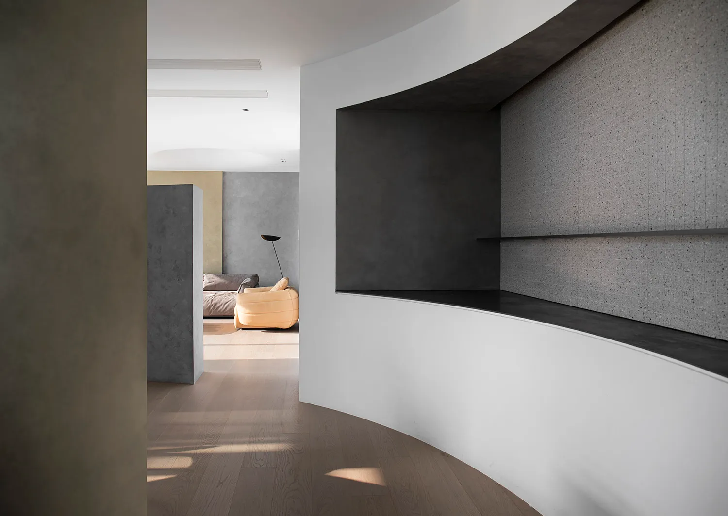A modern residential interior with concrete walls and wooden flooring.