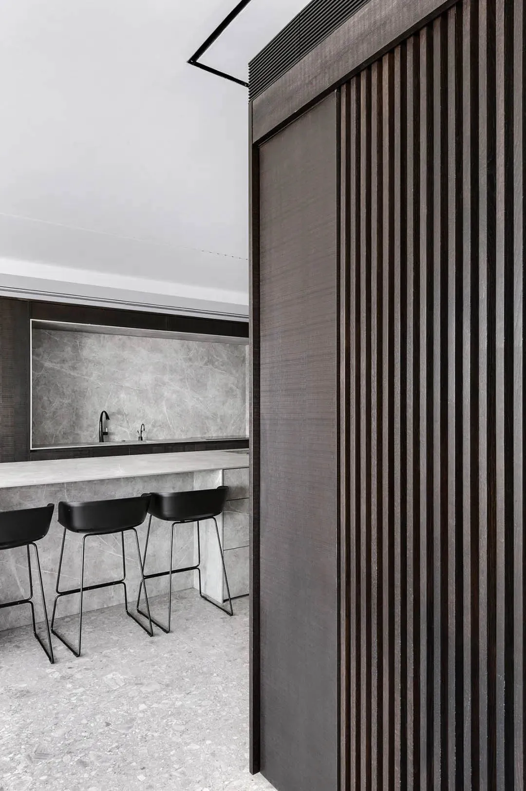 Modern kitchen with dark wooden cabinets and grey marble countertops