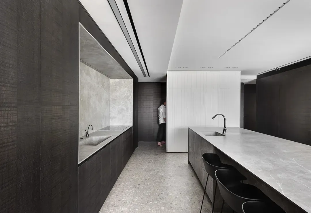 Modern minimalist kitchen featuring marble countertops and walls