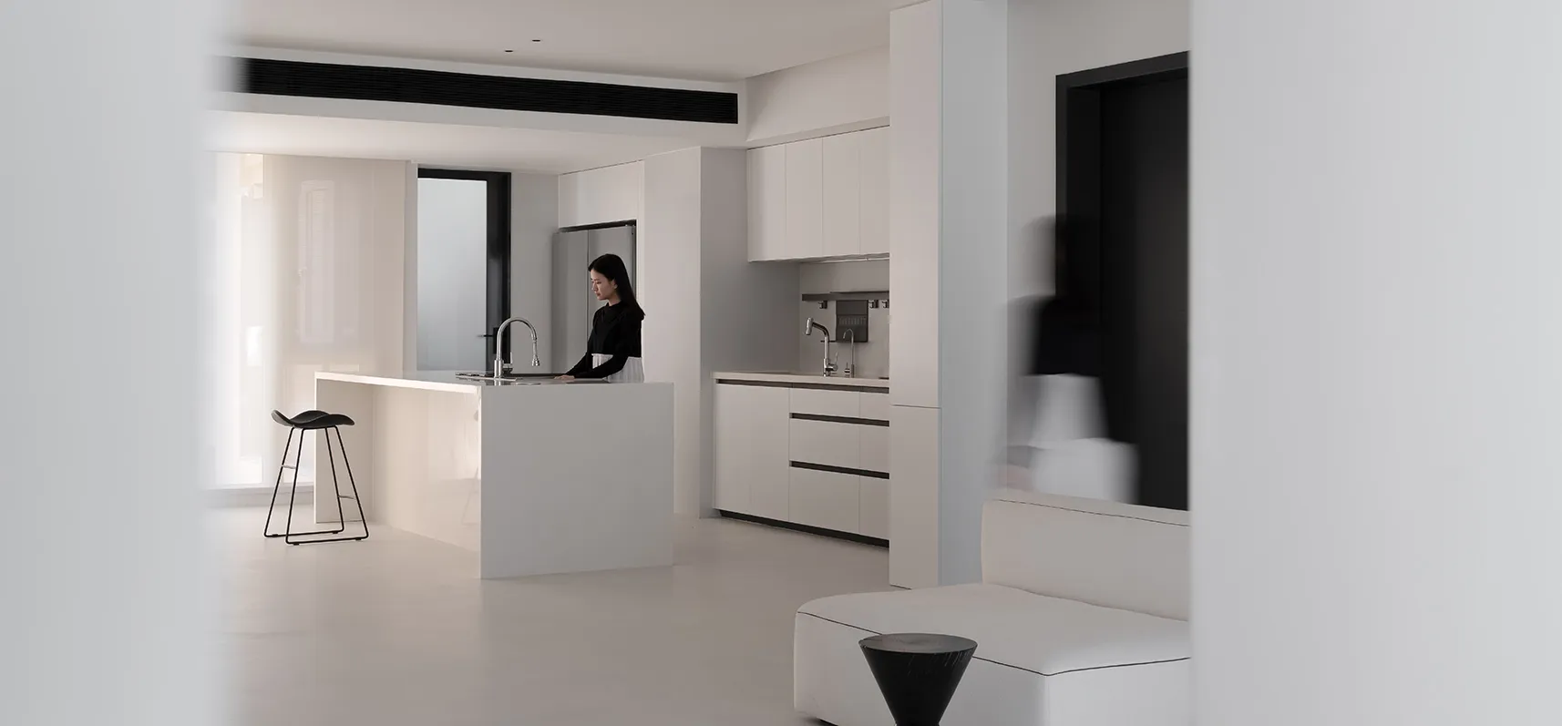 A modern minimalist kitchen with white cabinets and white countertops.