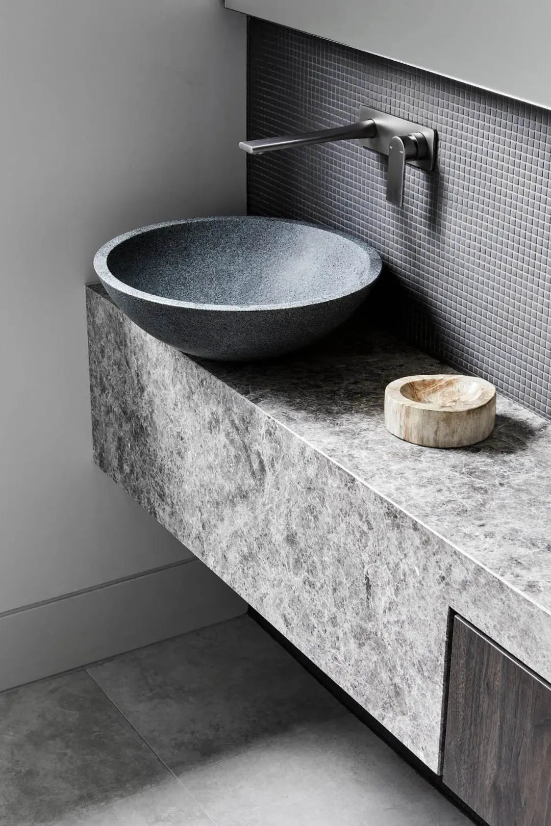 A minimalist bathroom with a granite countertop and sink.