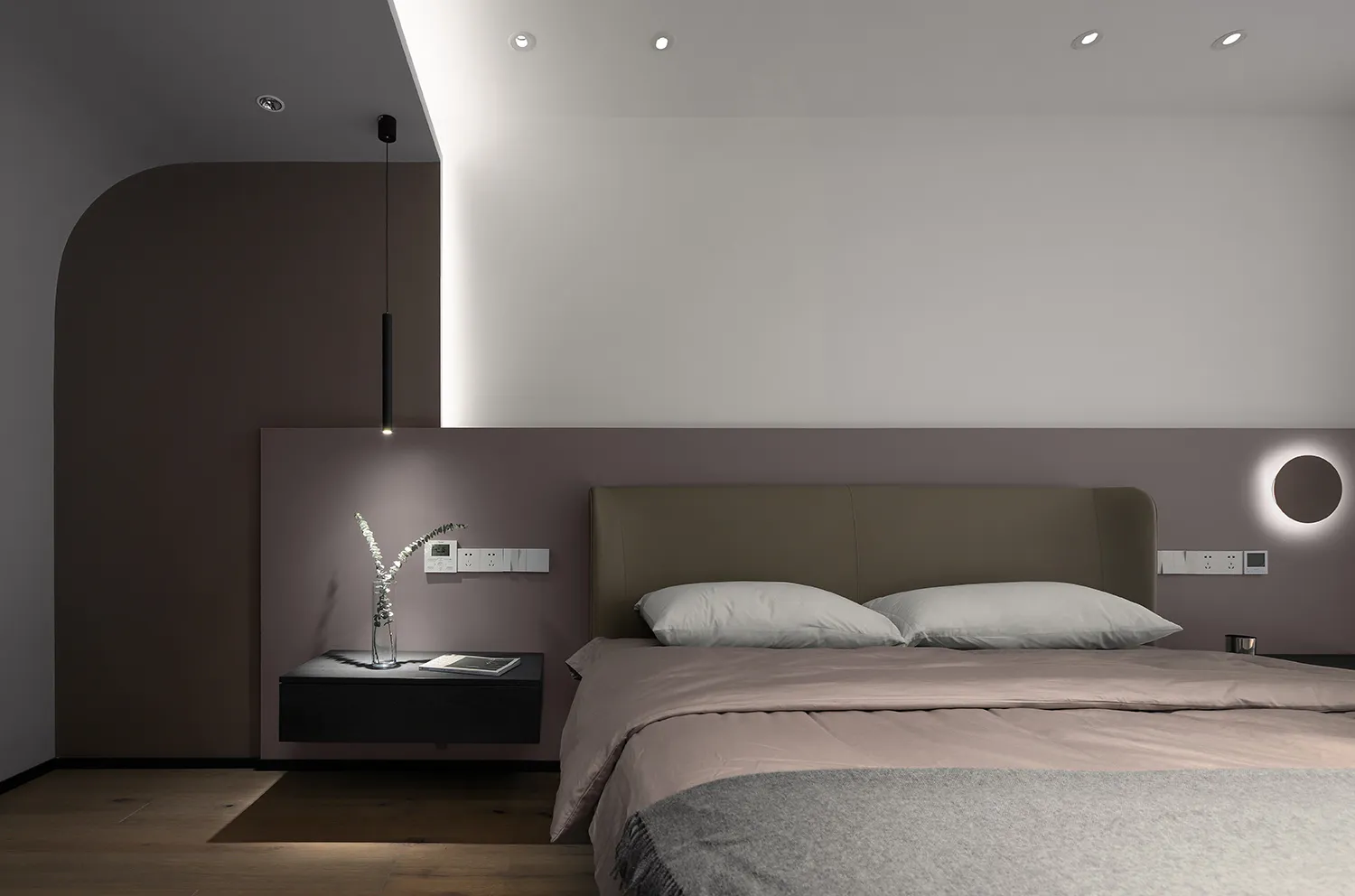 A minimalist bedroom with a sleek bed and floating nightstand.