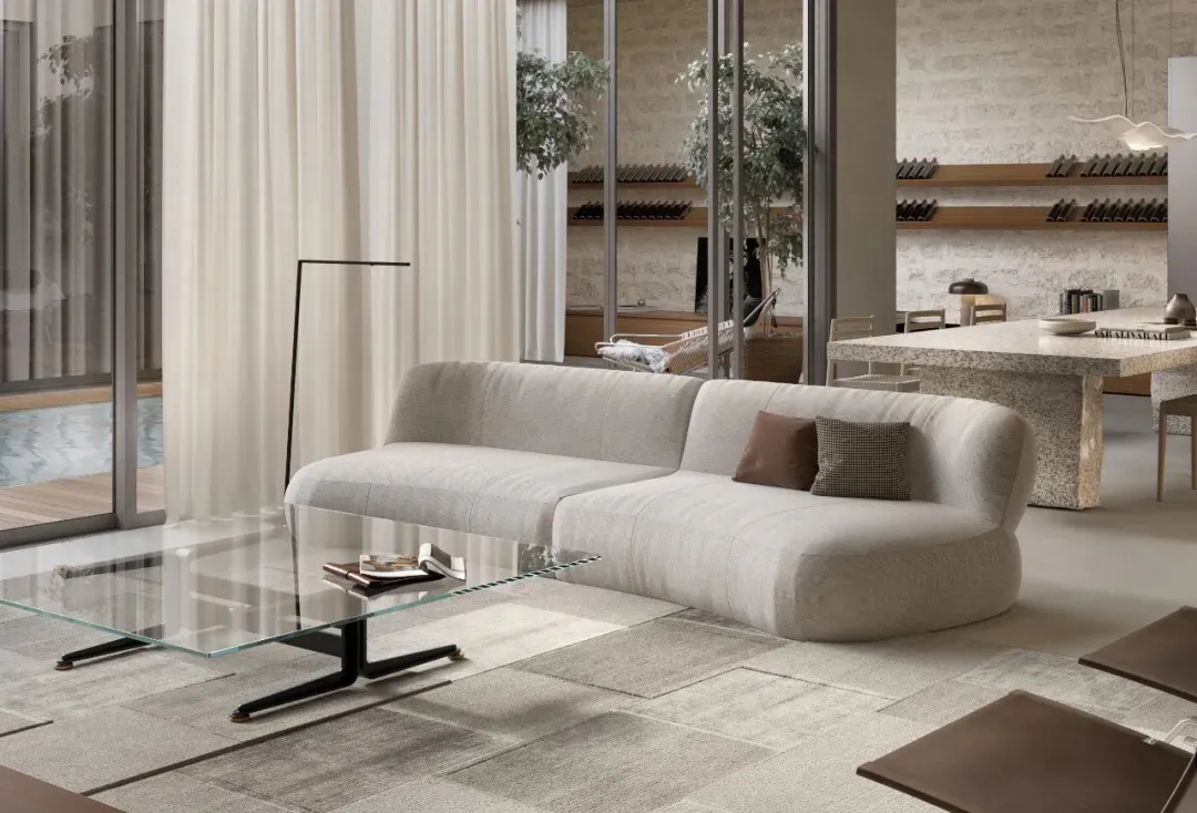 A modern living room featuring a stylish couch, glass coffee table, and minimalist decor.