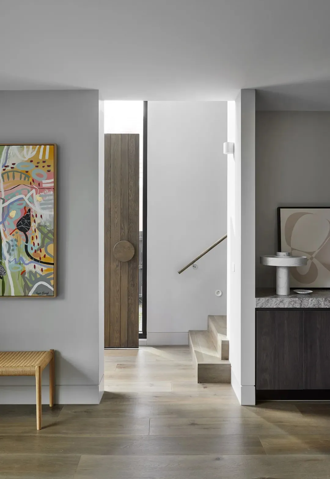 A contemporary minimalist staircase with wooden steps and a white marble floor.