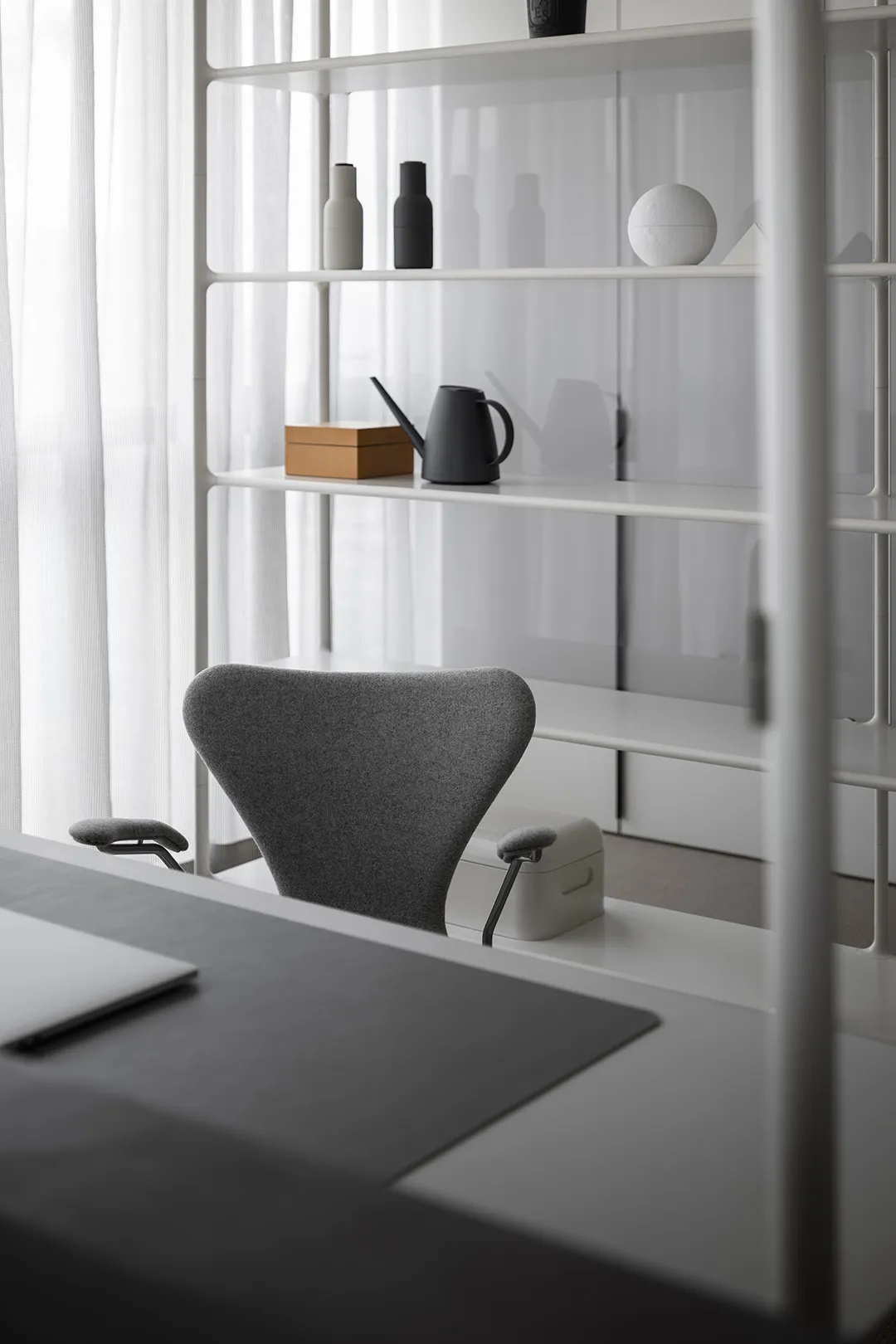 Minimalist office workspace featuring a white waterproof board and a grey office chair.