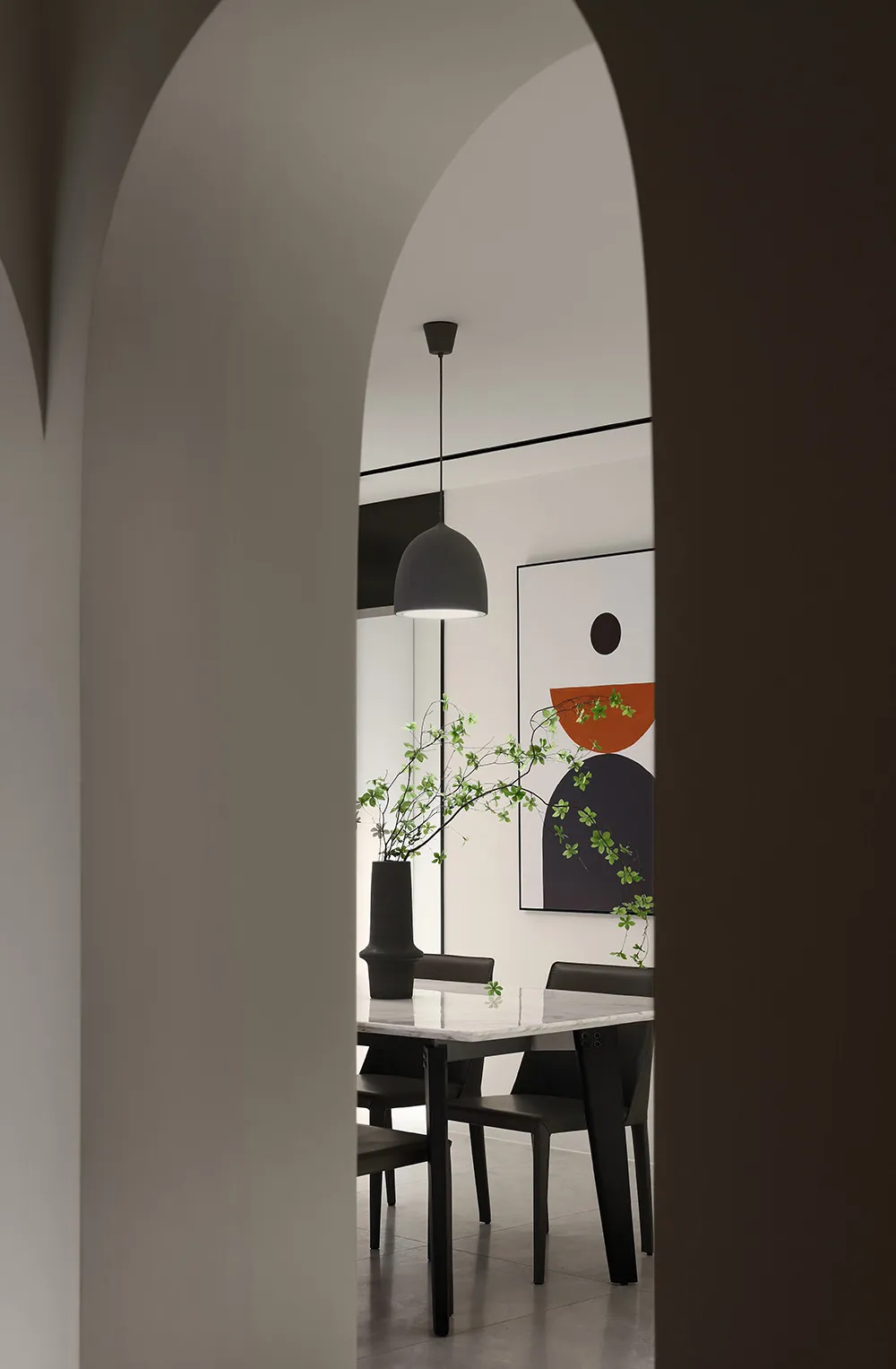 Modern dining room featuring a marble table and black chairs.