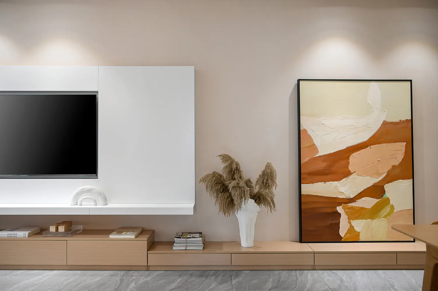 A modern living room featuring minimalist design with wood furniture, a flat-screen TV, and a vibrant abstract painting on th