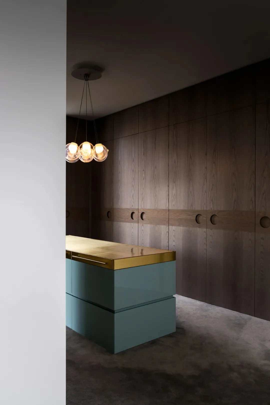 Modern minimal kitchen with wooden cabinets, metal accents, and glass countertops.