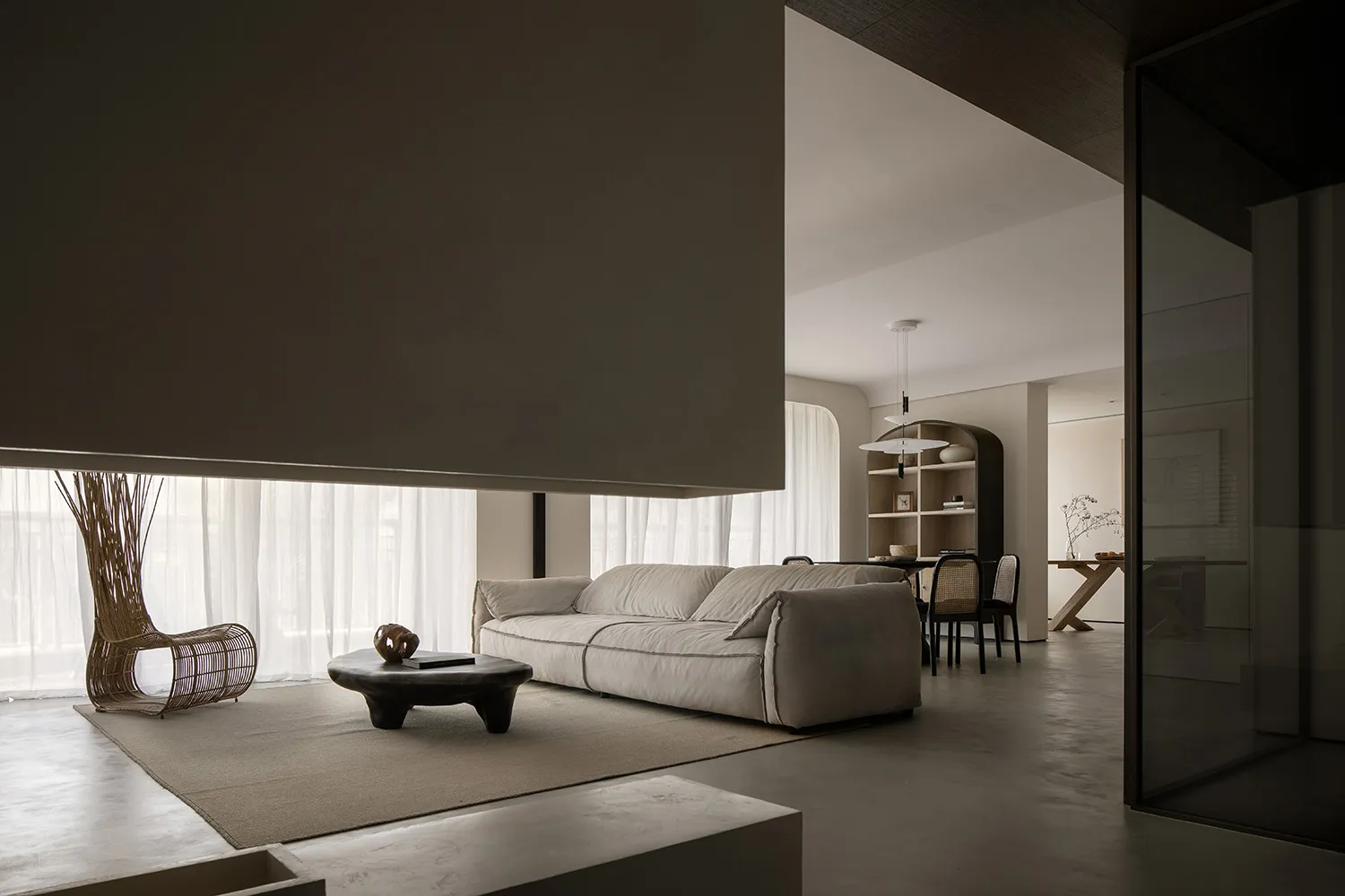 Modern minimalist living room with concrete elements and a comfortable sofa.