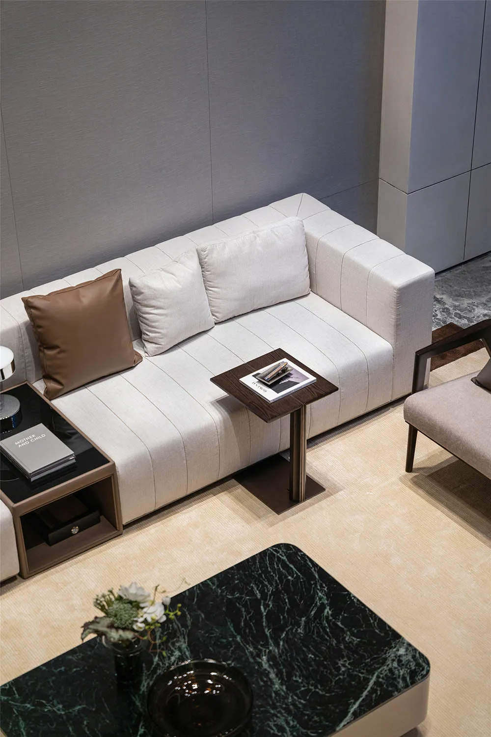 Modern minimalist living room featuring a fabric sofa with throw pillows and a marble coffee table.
