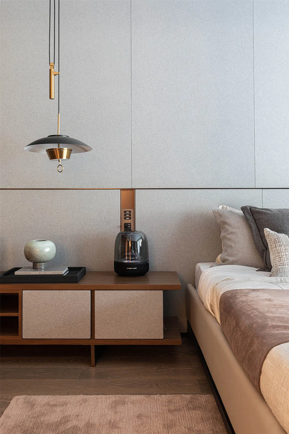A modern bedroom featuring textured grey walls and a minimalist design.