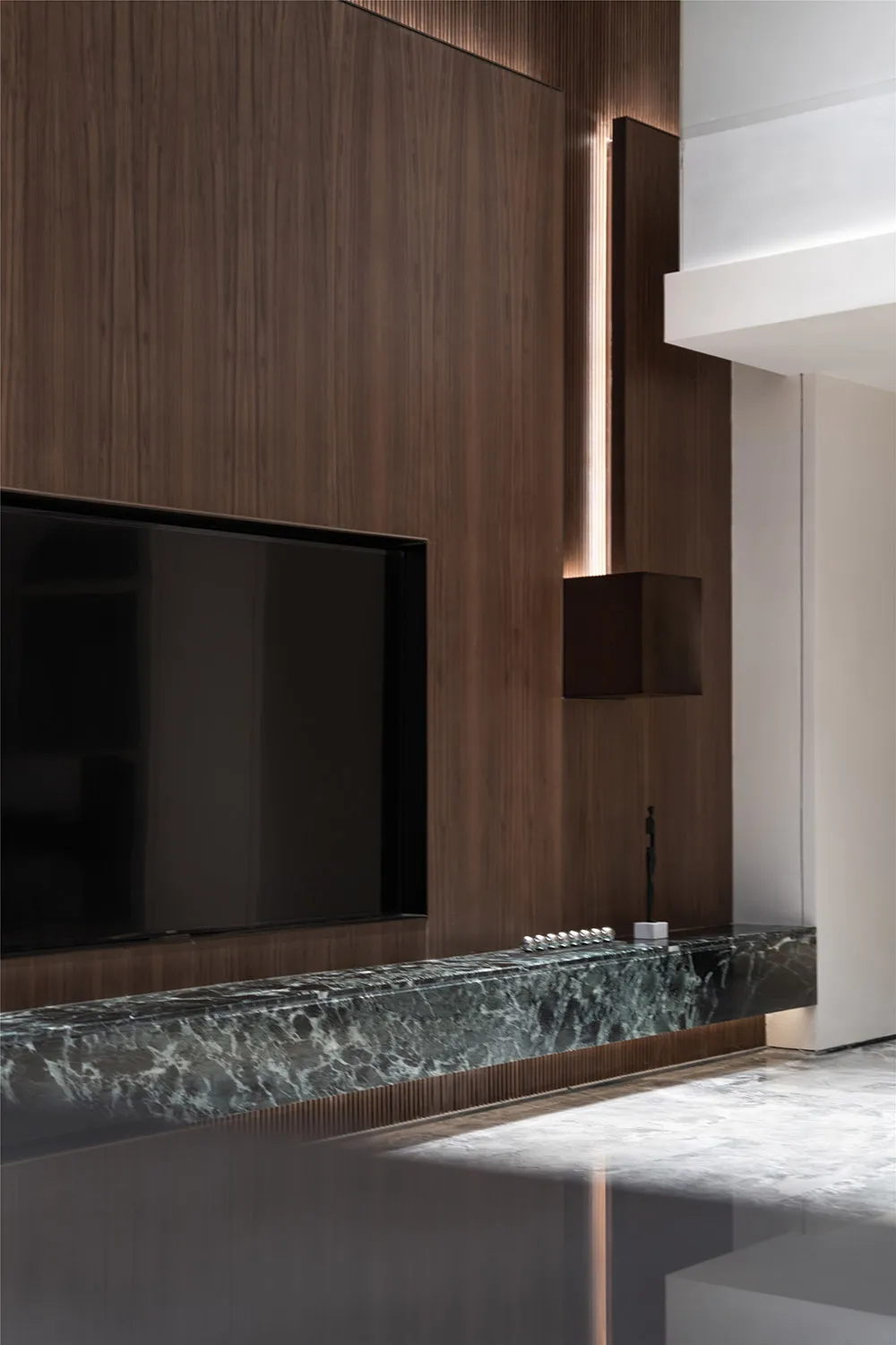 A modern interior space featuring wooden panels, leather furniture, and marble countertops.