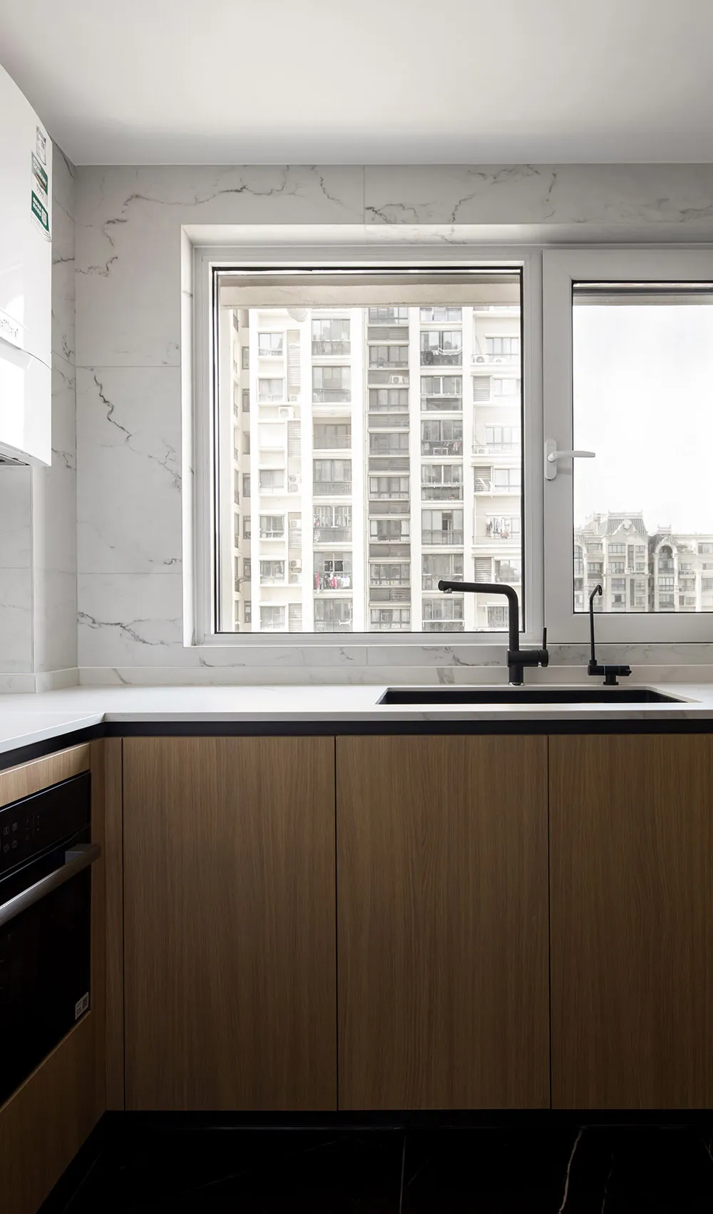 Modern kitchen with marble backsplash and black accents