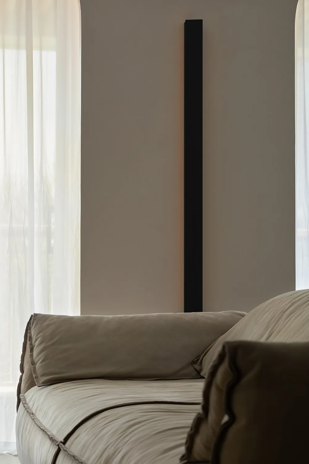 Minimalist living room featuring plush, beige fabric furniture