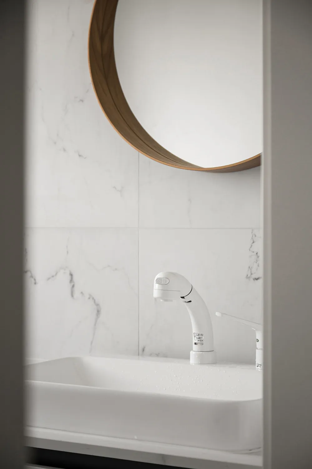 Modern bathroom interior designed with white marble tiles.