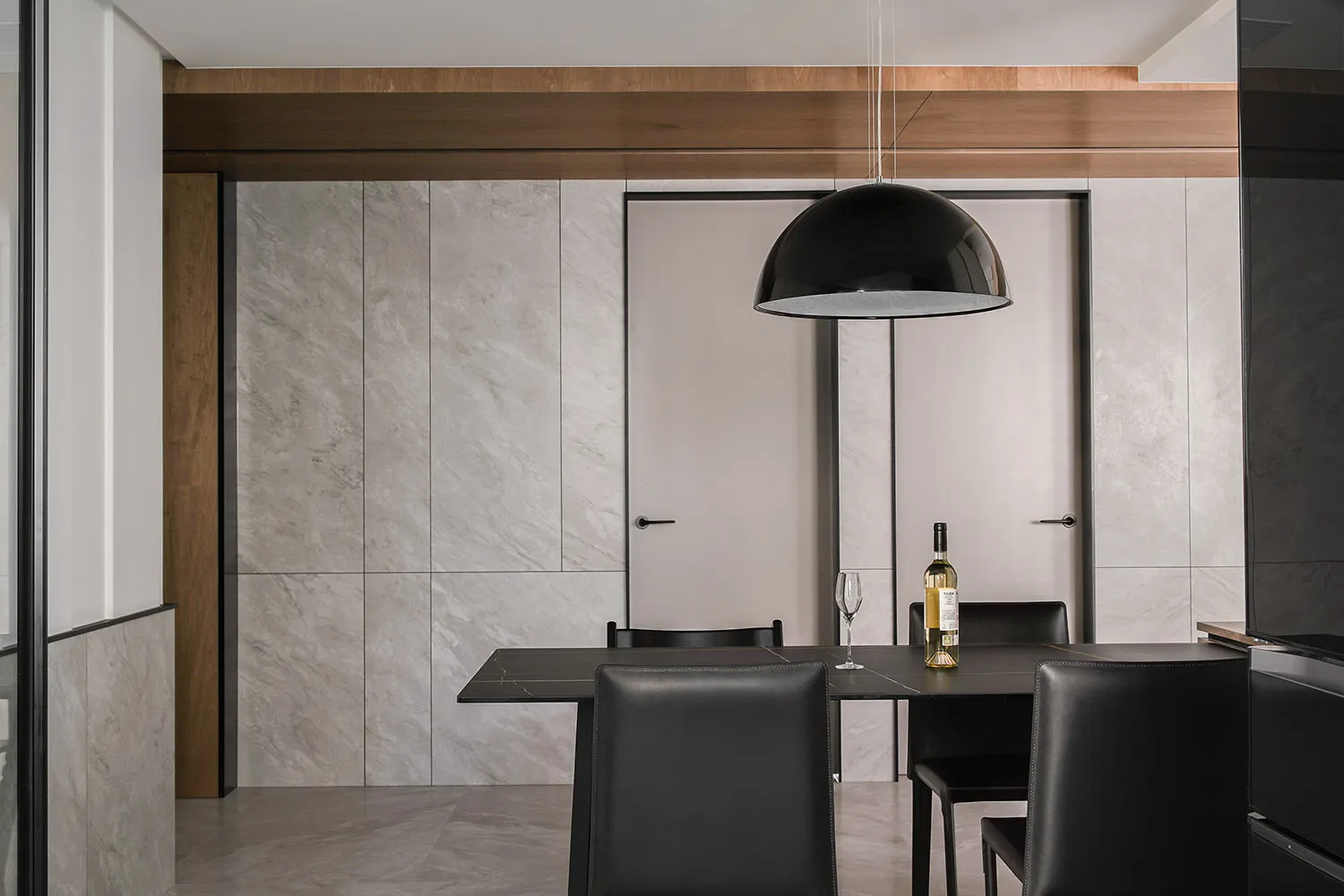 Modern dining room with a marble table and black chairs.
