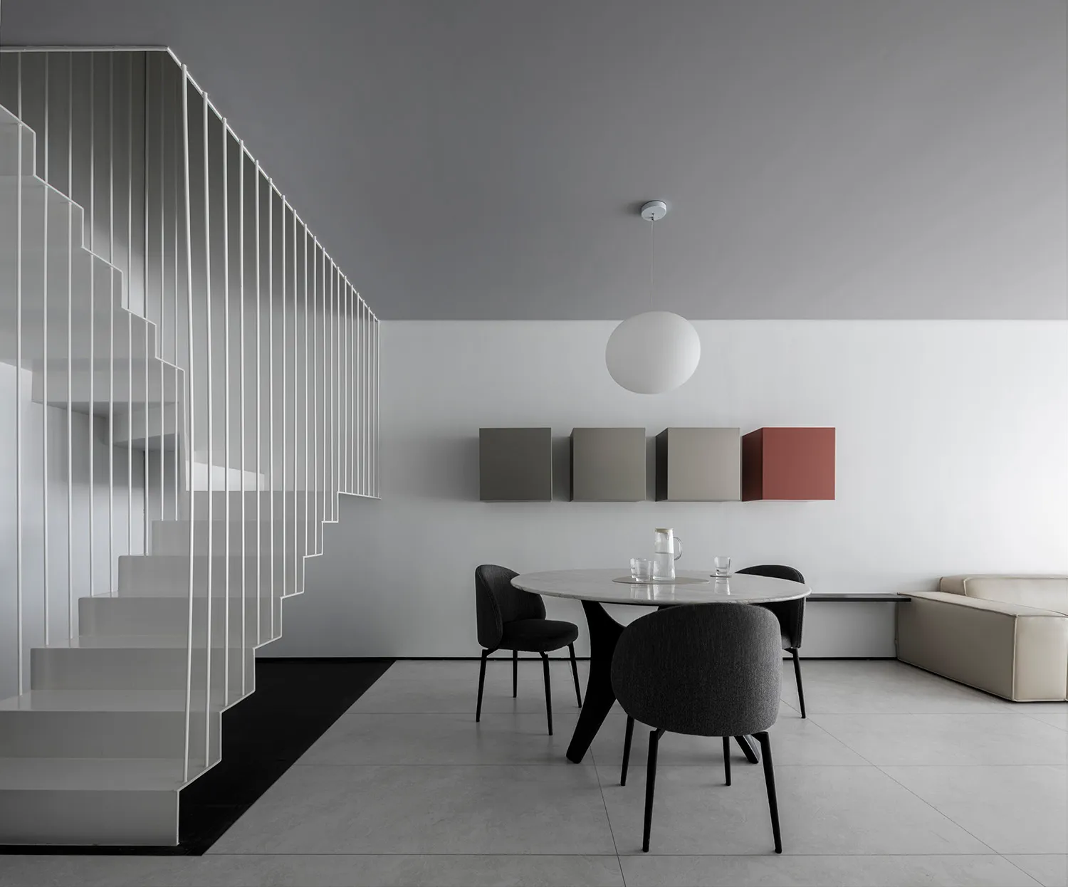 A minimalist modern dining room featuring sleek, black chairs and a white marble table with a black base.
