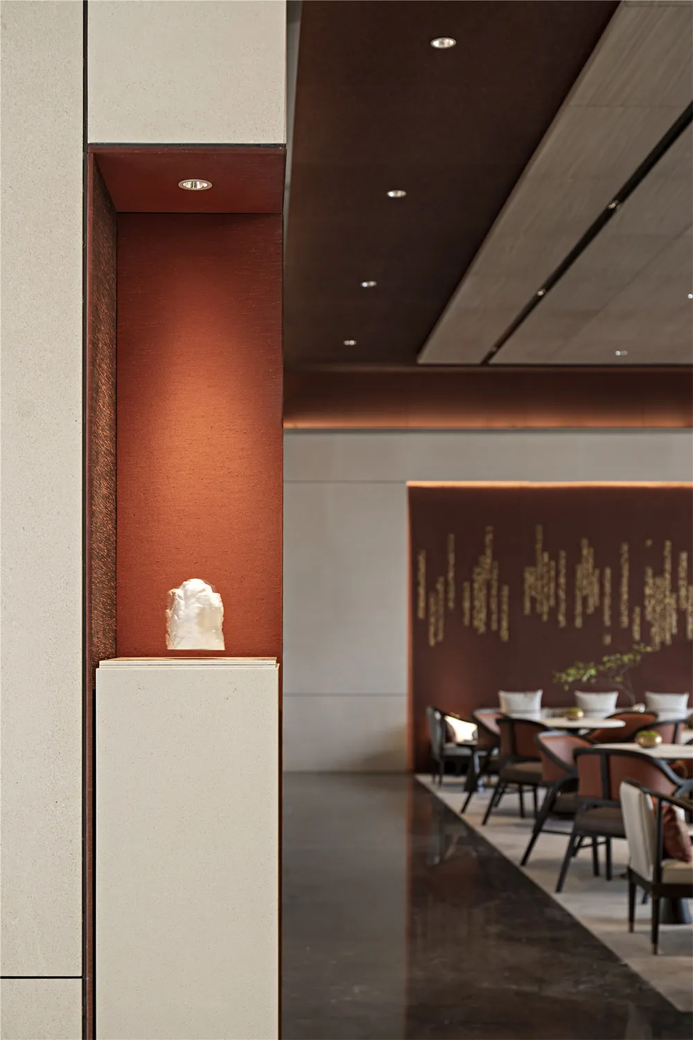 A modern restaurant interior featuring metallic texture red walls and a minimalist design.