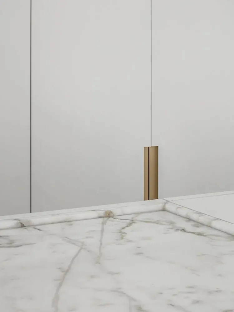 A minimalist modern interior design featuring marble surfaces with subtle gold accents.
