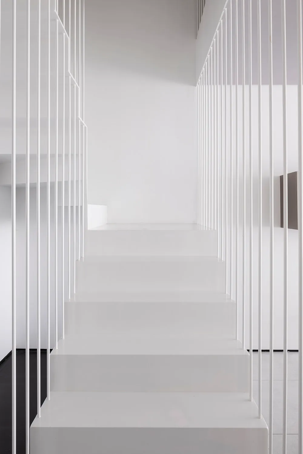 A minimalistic, modern staircase with white railings and steps.