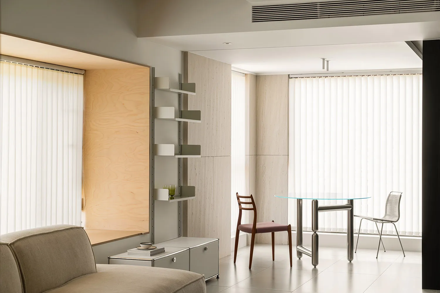 Modern, minimalist living room with neutral tones and simple furnishings.