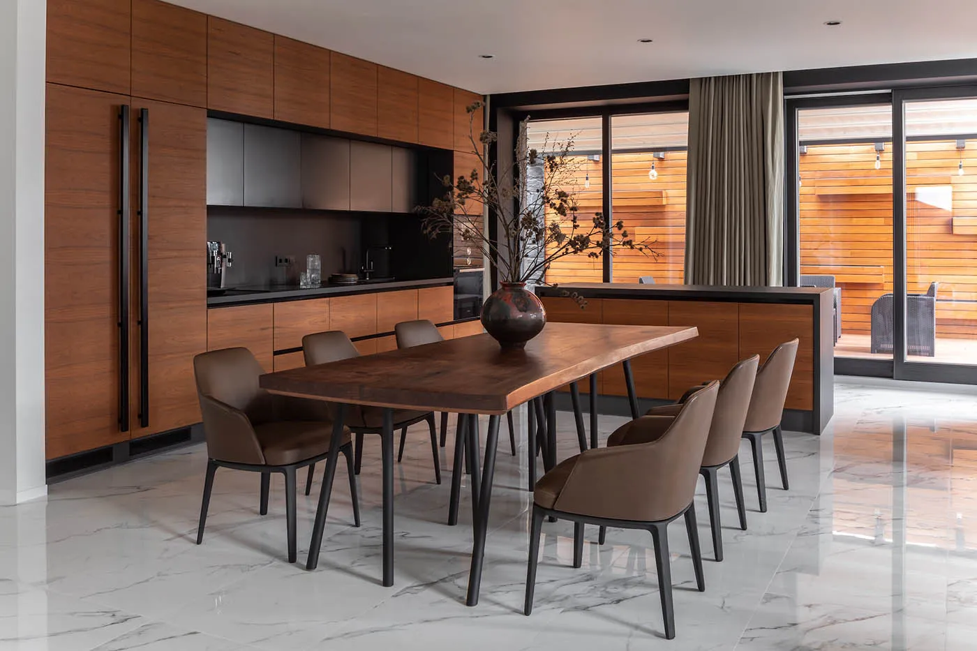 A modern residential kitchen featuring marble and wood finishes.